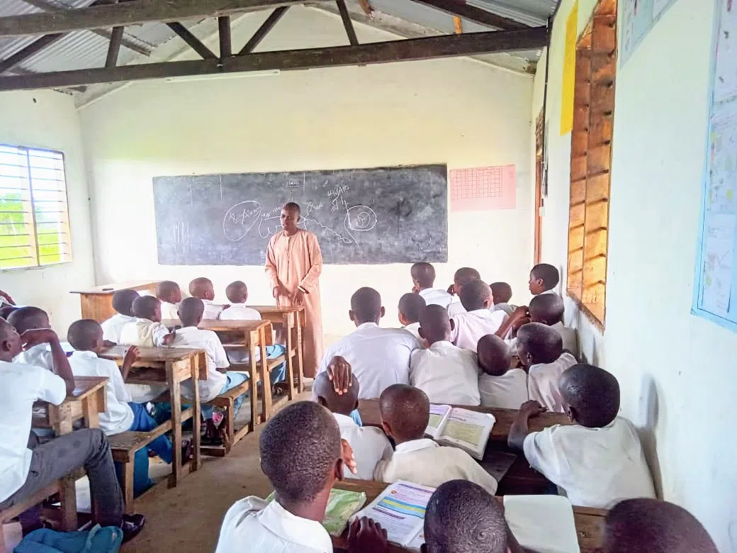 A group of boys sitting in a classroom with their teacher