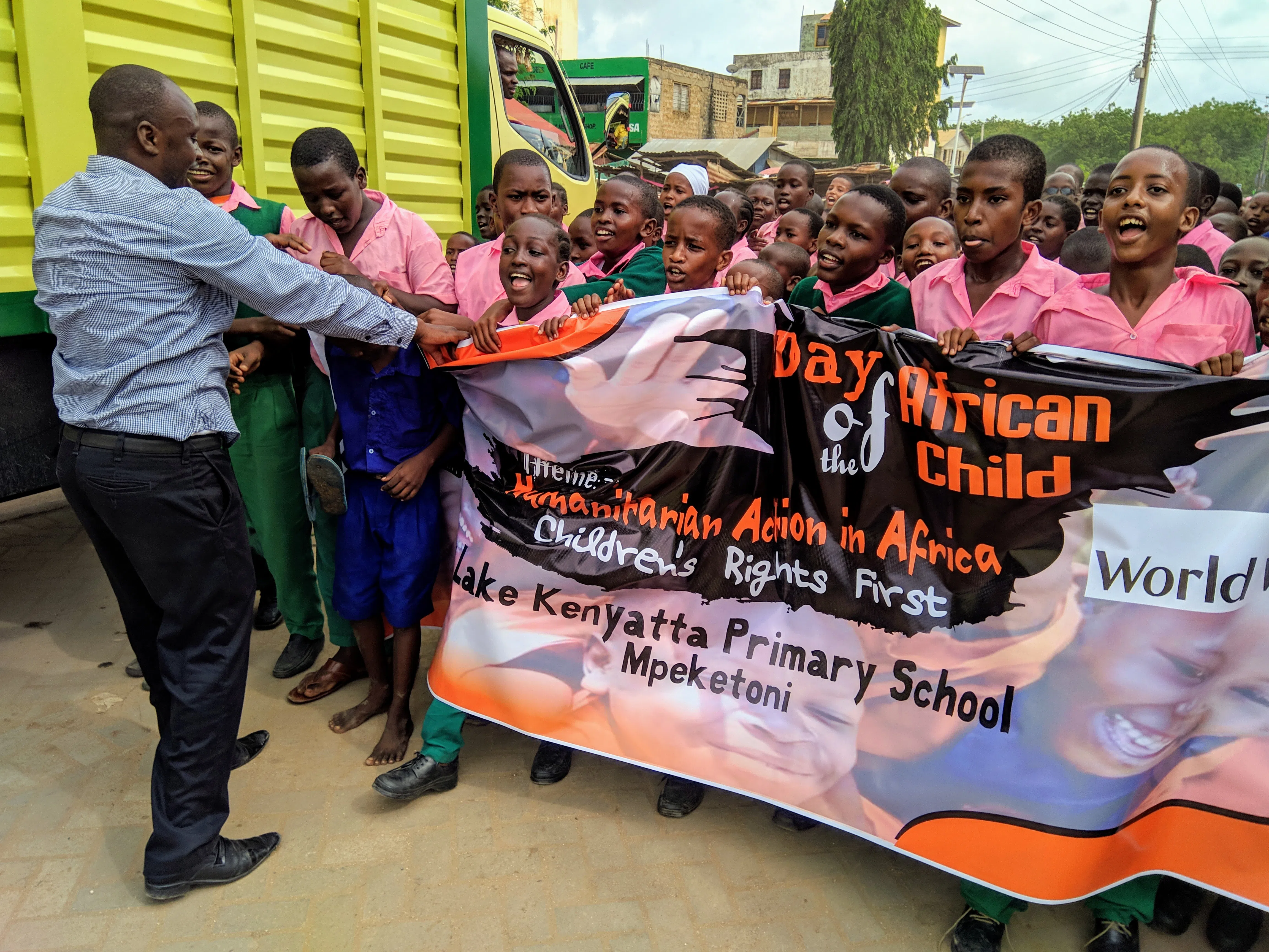 A group of kenyan boys and their teacher marching for the day of the african child