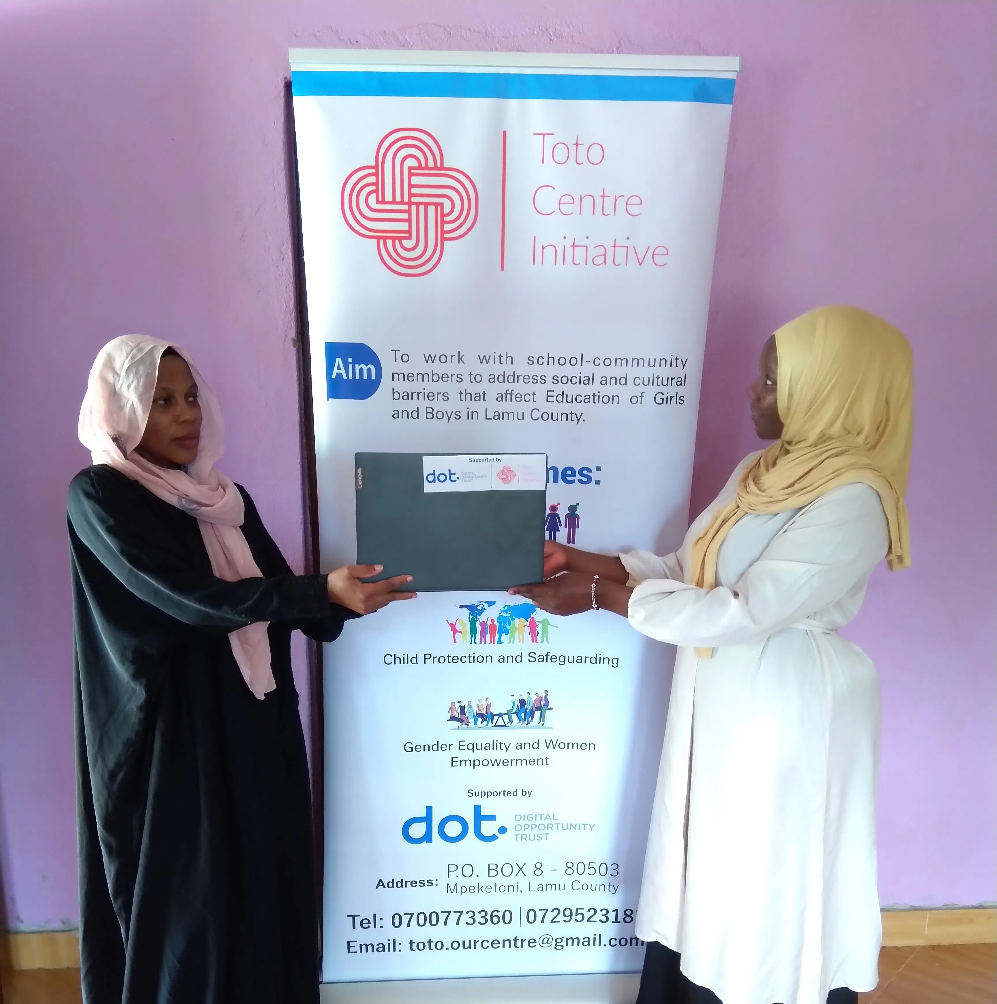 Two kenyan muslim girls holding a laptop