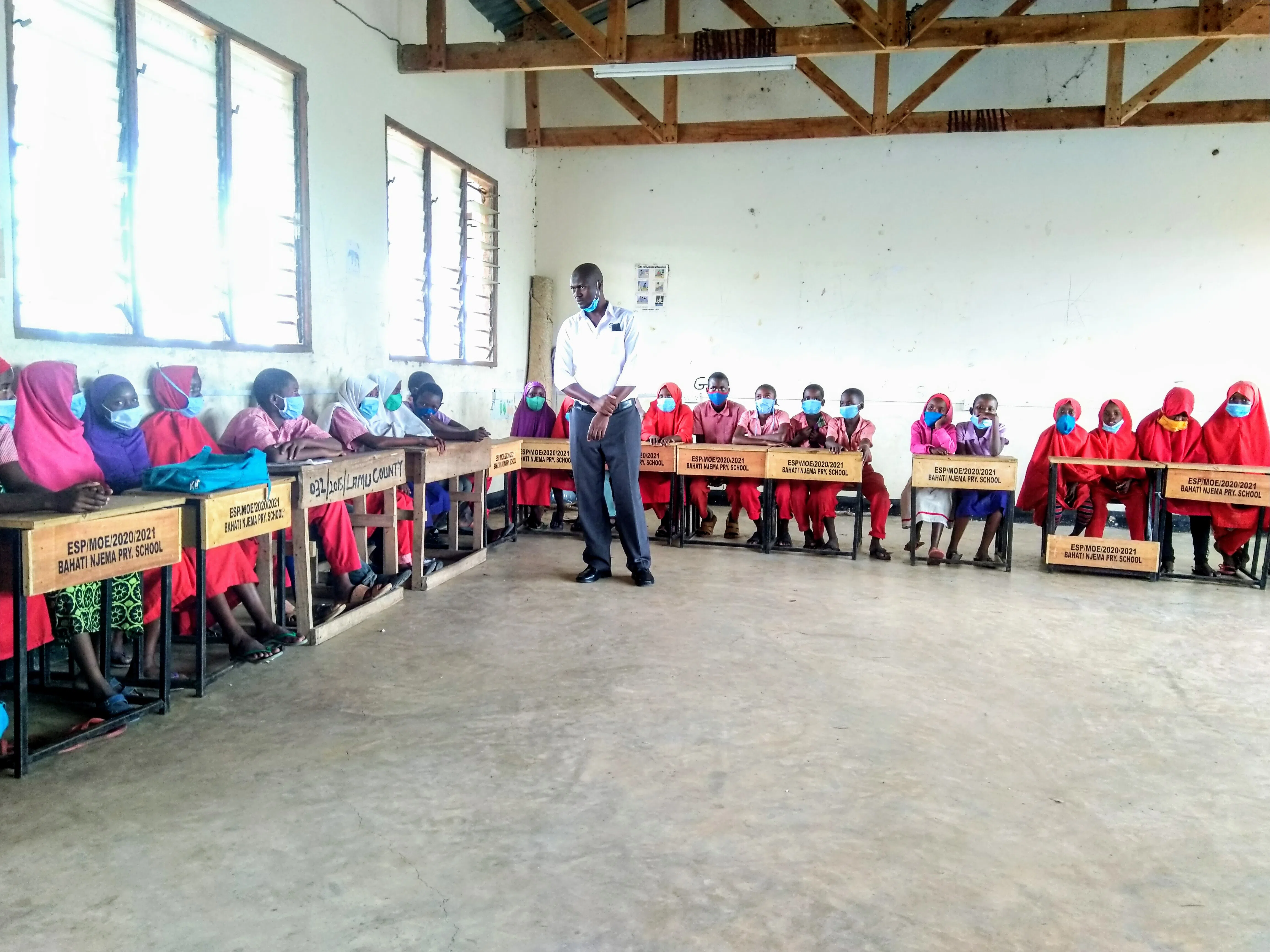 A teacher teaching a group of kenyan boys in the classroom