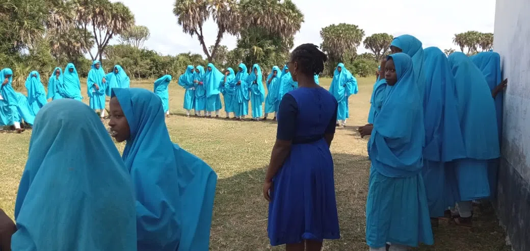 A group of kenyan muslim girls learning life skills outside 