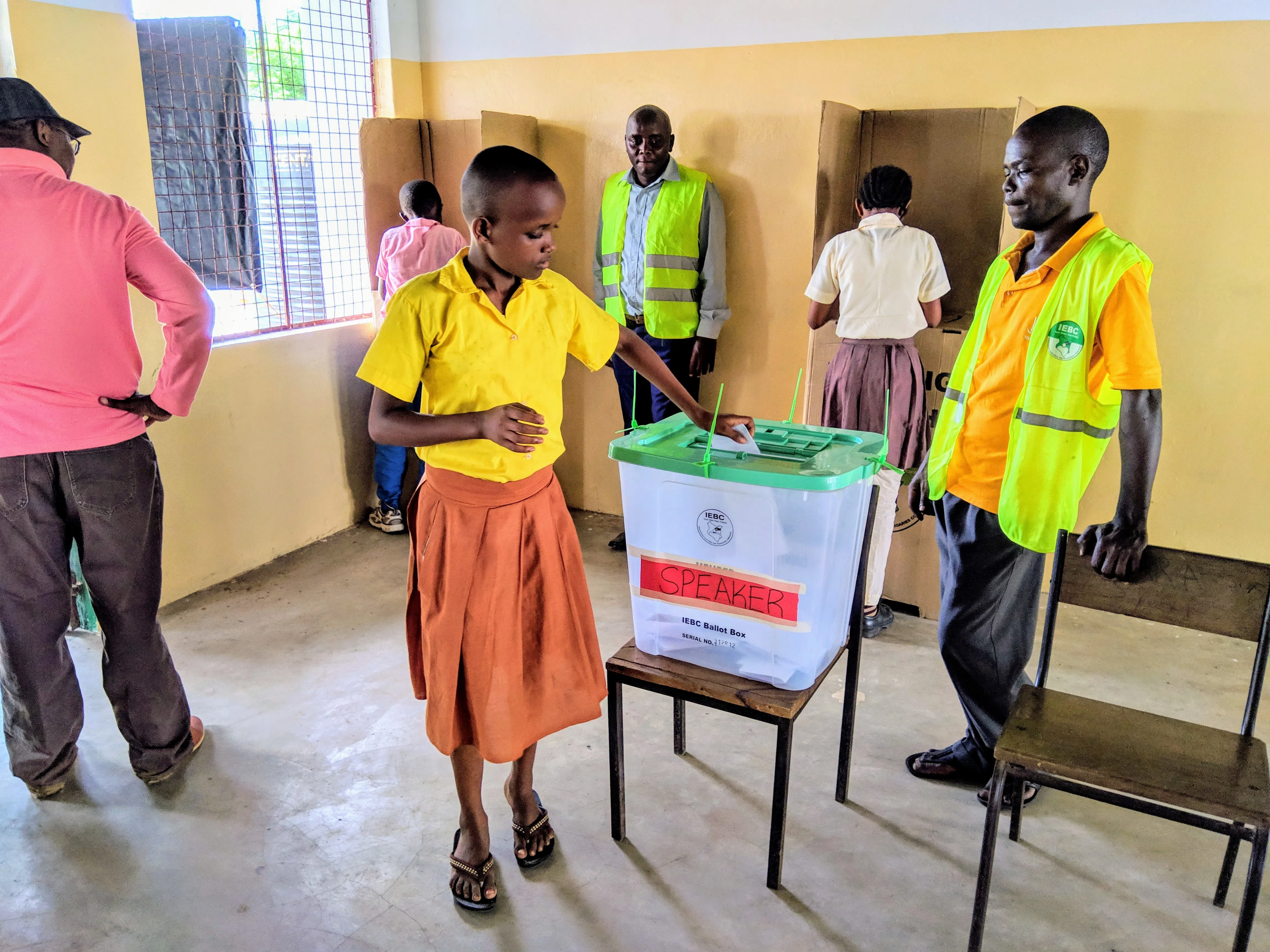 A girl in a classroom voting for election day